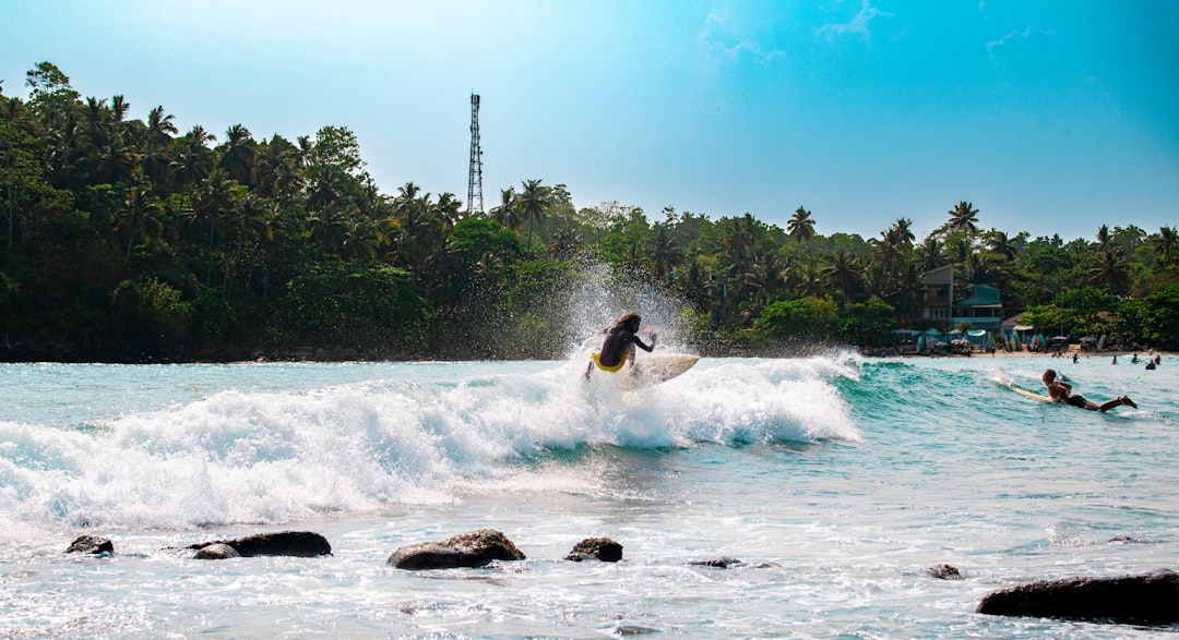 An athletic person wakeboarding at high speed, carving through the bright blue water and creating a dynamic spray on a sunny day.