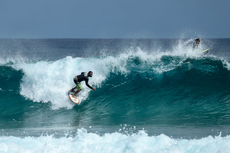 Dynamic action shot of a skilled surfer executing a powerful, sharp turn on a clean ocean wave, kicking up spray and showcasing a breakthrough in performance.